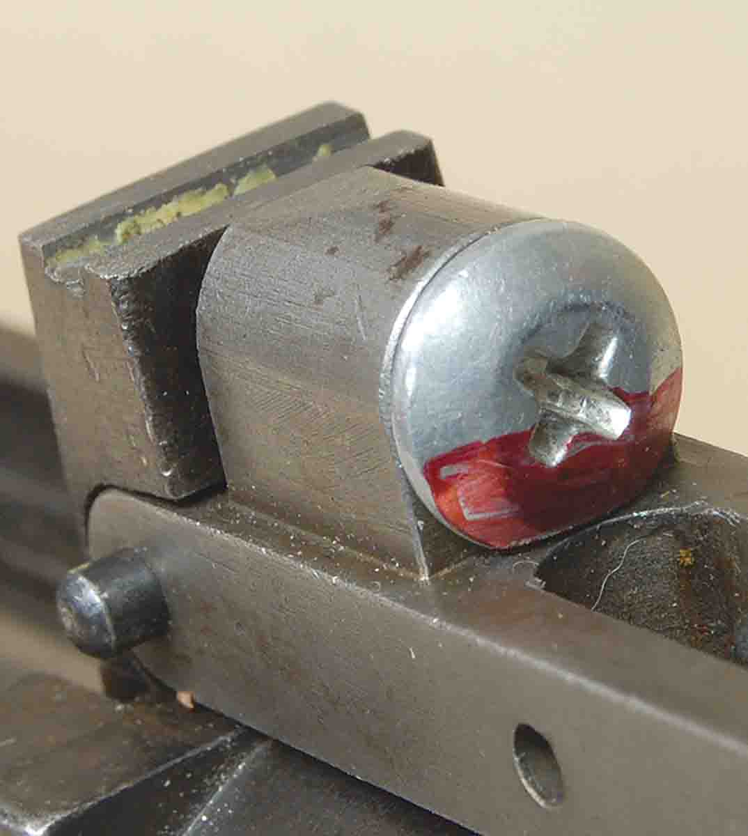 The machine screw inserted in the housing; the area to be fit by grinding is shown in red.